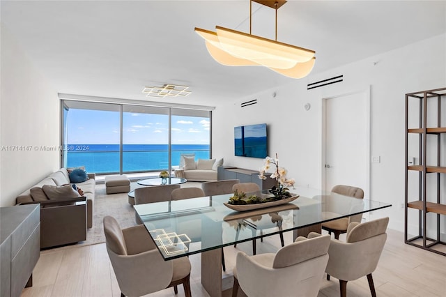 dining area with light hardwood / wood-style floors and a wall of windows