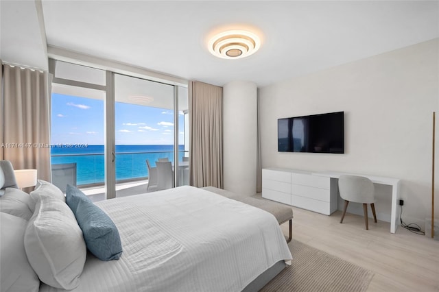 bedroom with light hardwood / wood-style flooring and a wall of windows