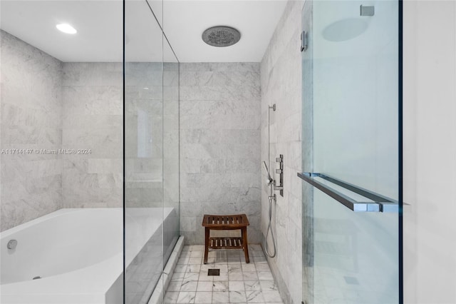 bathroom featuring tile walls and independent shower and bath