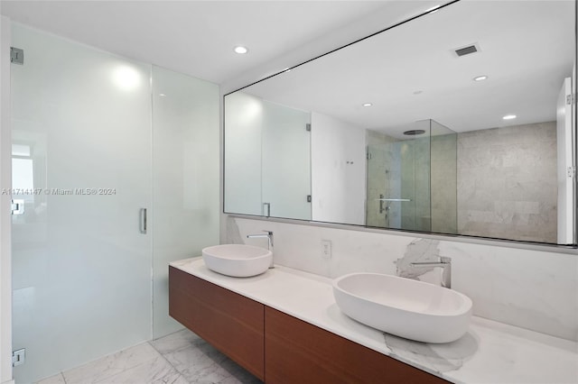 bathroom featuring vanity, an enclosed shower, decorative backsplash, and tile walls