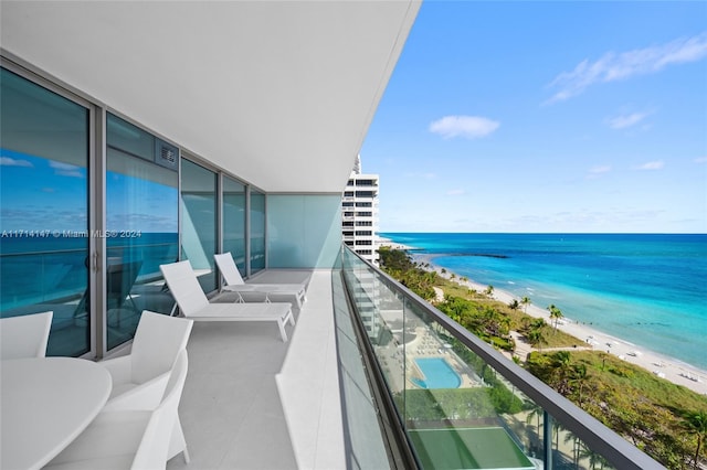 balcony featuring a water view and a view of the beach