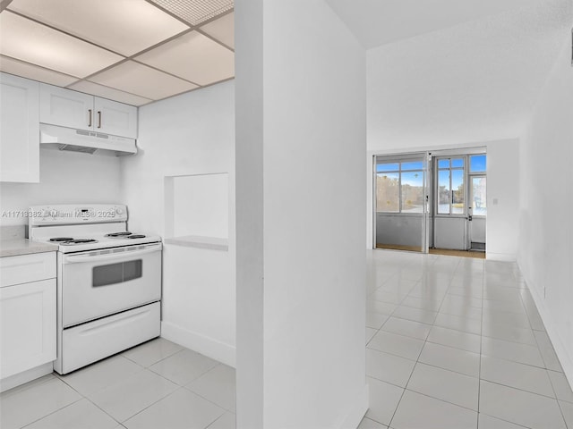 kitchen featuring white cabinetry, a paneled ceiling, light tile patterned floors, and electric range