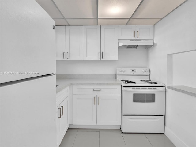 kitchen with white appliances, a paneled ceiling, white cabinets, and light tile patterned flooring