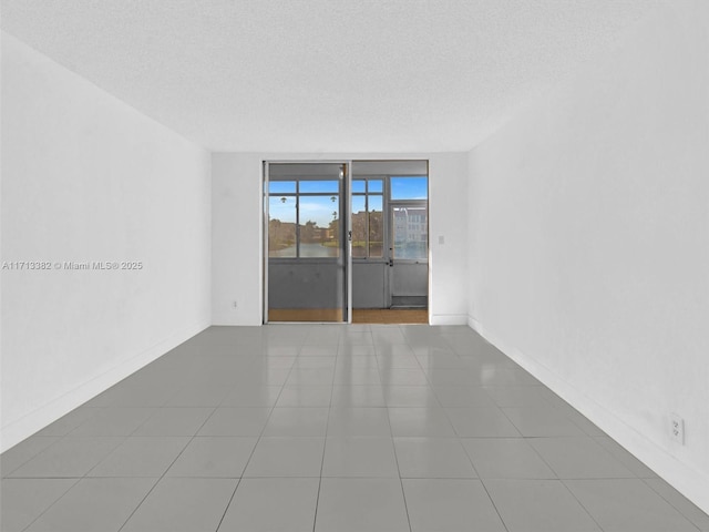 tiled spare room with a textured ceiling