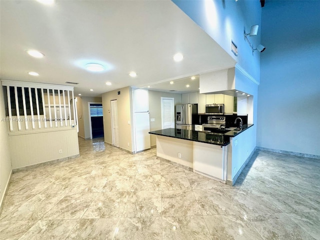 kitchen featuring sink, white cabinetry, kitchen peninsula, and appliances with stainless steel finishes