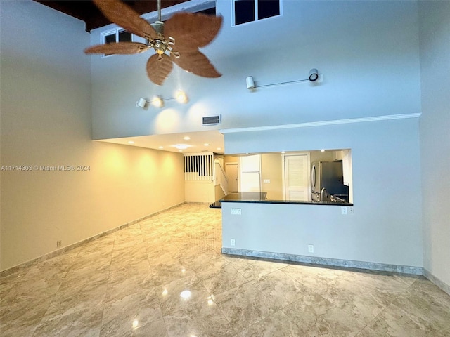 interior space featuring a towering ceiling and ceiling fan