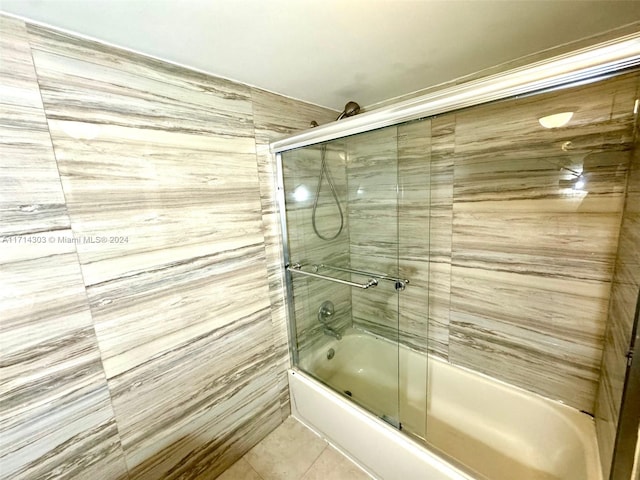 bathroom with tile patterned flooring and combined bath / shower with glass door