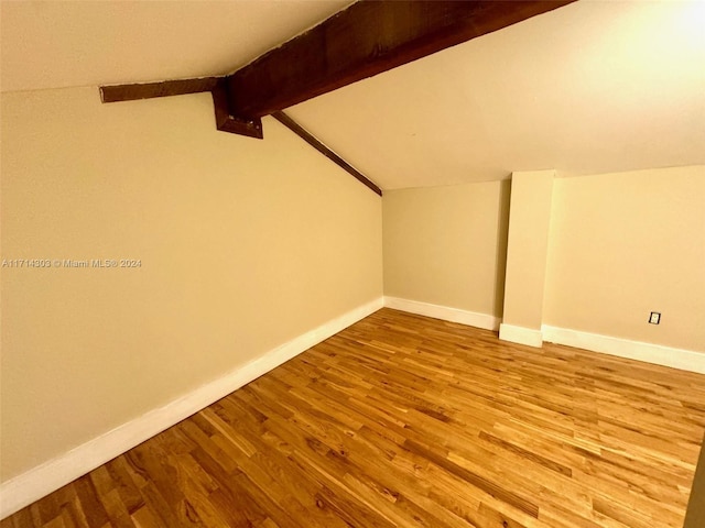 bonus room with lofted ceiling with beams and hardwood / wood-style flooring