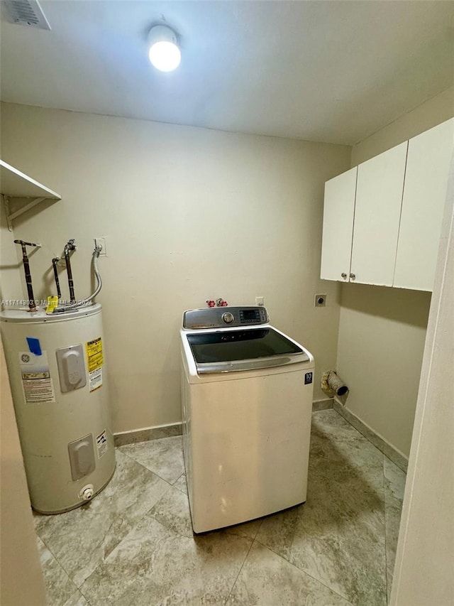 clothes washing area featuring electric water heater, cabinets, and washer / dryer