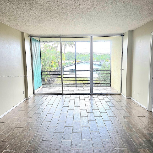 spare room with a textured ceiling and expansive windows