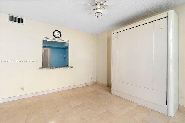 unfurnished bedroom featuring ceiling fan and a textured ceiling