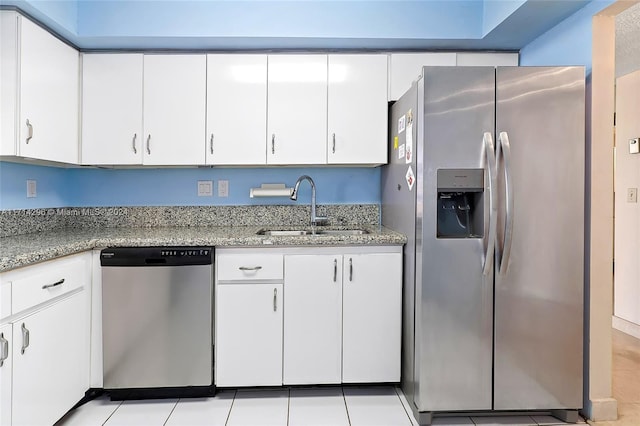 kitchen with white cabinets, light tile patterned floors, sink, and appliances with stainless steel finishes