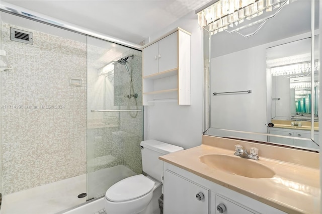 bathroom featuring vanity, toilet, and a shower with door