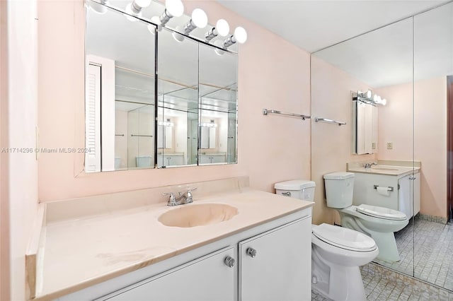 bathroom featuring tile patterned flooring, vanity, and toilet