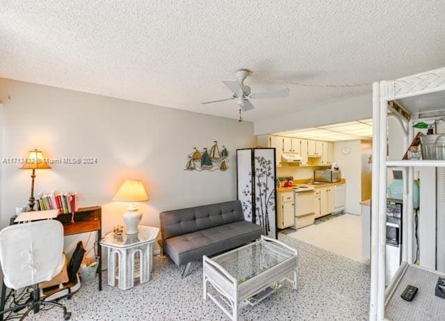 living room with a textured ceiling and ceiling fan