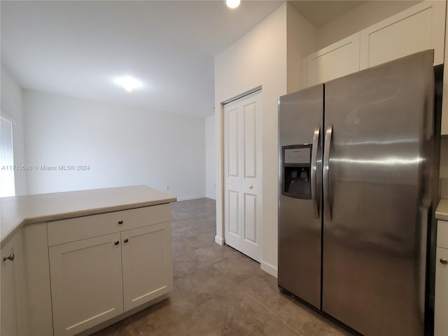 kitchen featuring stainless steel fridge and white cabinets