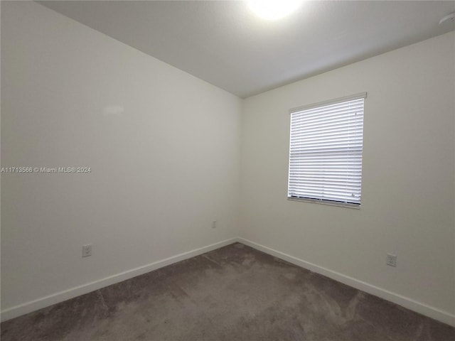 empty room with dark colored carpet