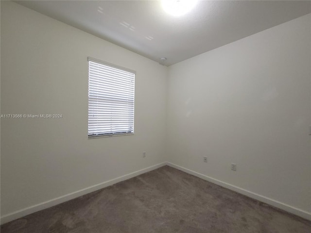 spare room with dark carpet