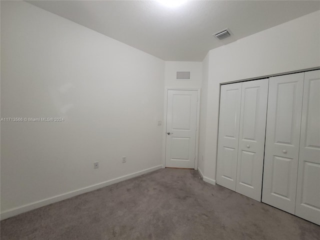 unfurnished bedroom with light carpet and a closet