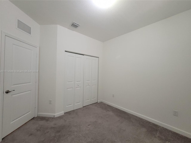 unfurnished bedroom with light carpet and a closet