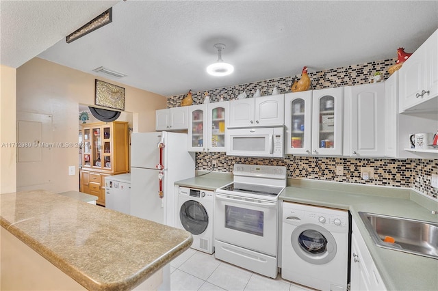 kitchen featuring white cabinetry, washer / dryer, white appliances, and kitchen peninsula