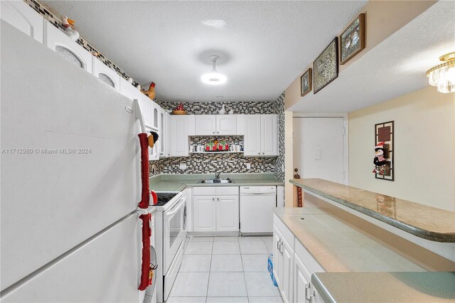 kitchen featuring white appliances, white cabinets, sink, decorative backsplash, and light tile patterned floors