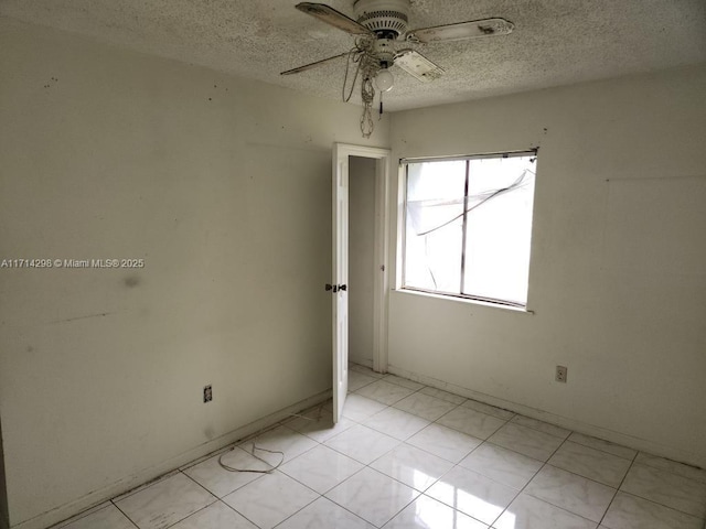 spare room with ceiling fan and a textured ceiling