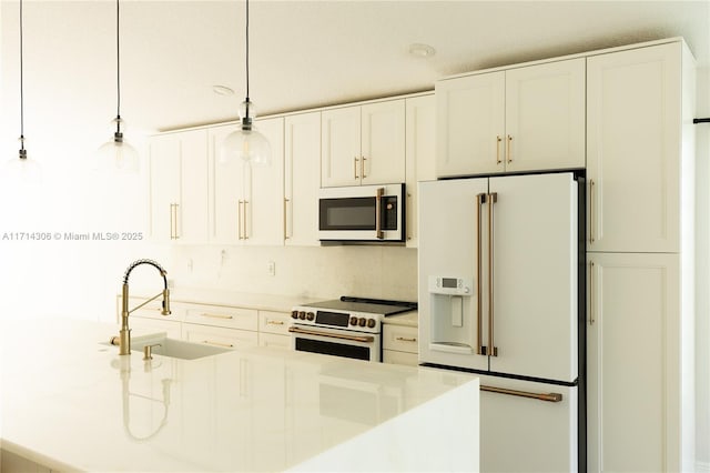 kitchen featuring light countertops, hanging light fixtures, white appliances, white cabinetry, and a sink