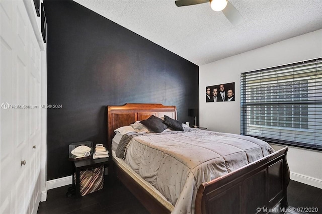 bedroom featuring ceiling fan, dark wood-type flooring, and a textured ceiling