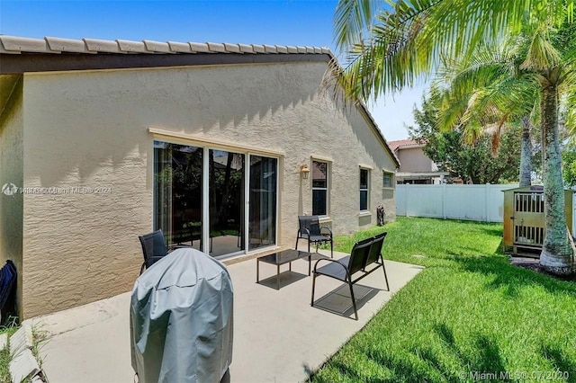 back of house featuring a lawn and a patio area