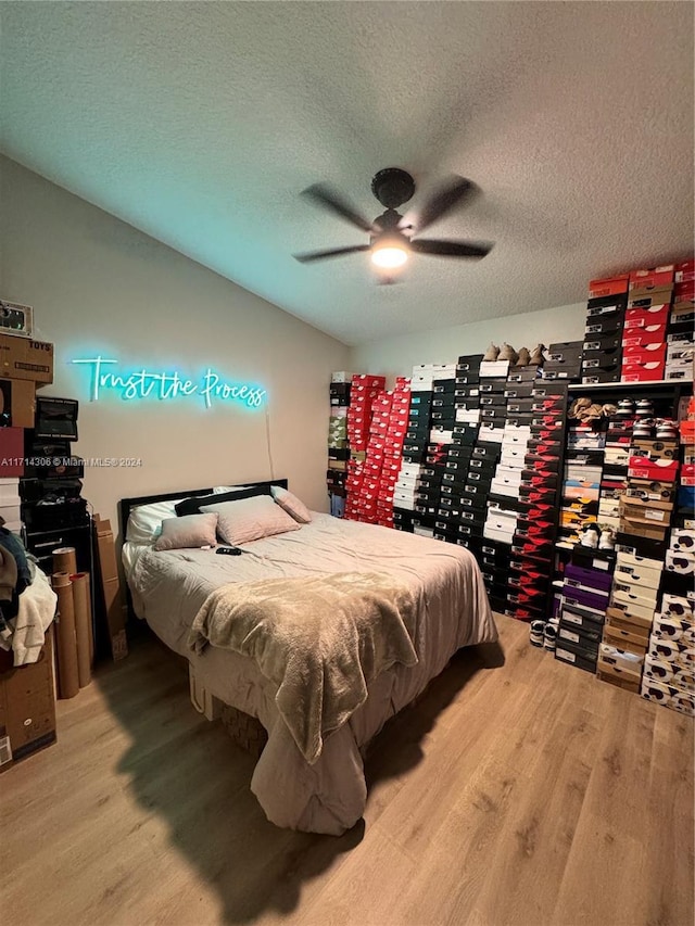 bedroom with wood-type flooring, a textured ceiling, and ceiling fan