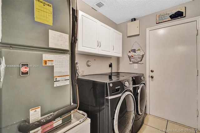 washroom featuring cabinets, a textured ceiling, heating unit, washing machine and clothes dryer, and light tile patterned flooring