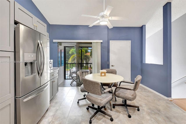 tiled dining room featuring ceiling fan and french doors