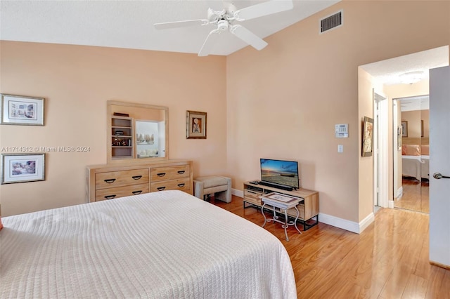 bedroom with connected bathroom, hardwood / wood-style flooring, and ceiling fan