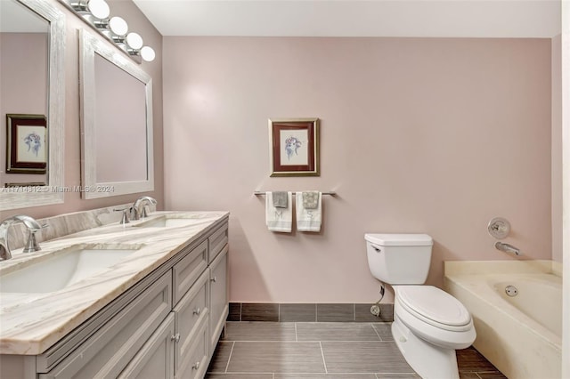 bathroom featuring a bathing tub, vanity, and toilet