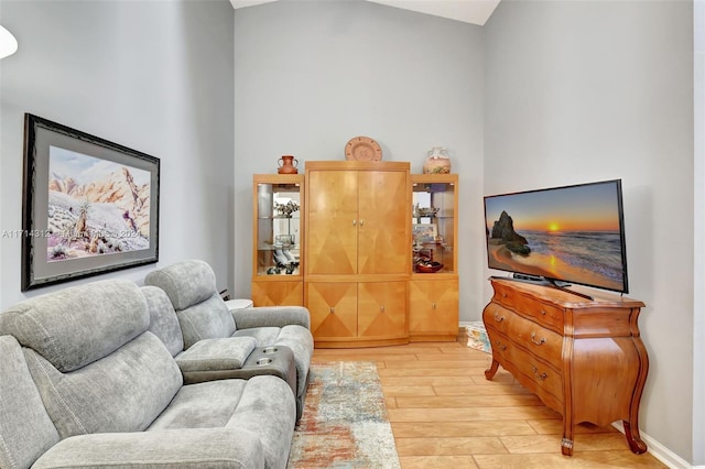 living room featuring light hardwood / wood-style flooring and lofted ceiling