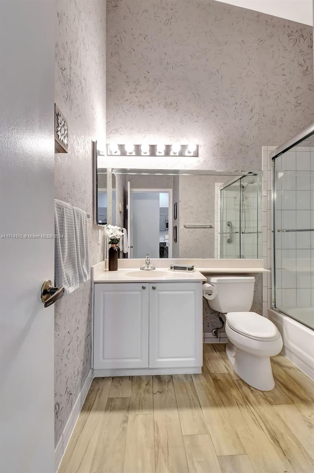 full bathroom featuring vanity, toilet, and enclosed tub / shower combo