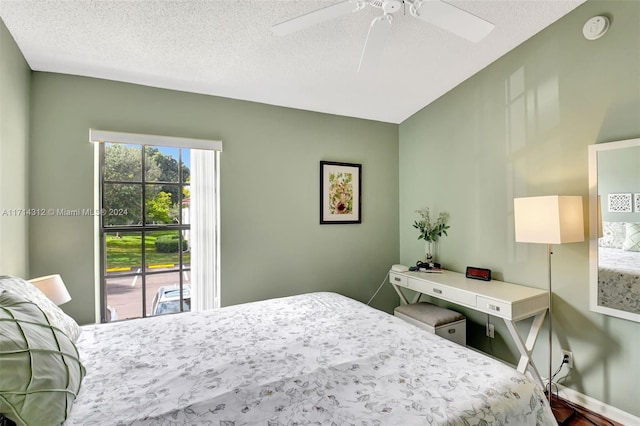 bedroom with hardwood / wood-style flooring, ceiling fan, access to exterior, and a textured ceiling