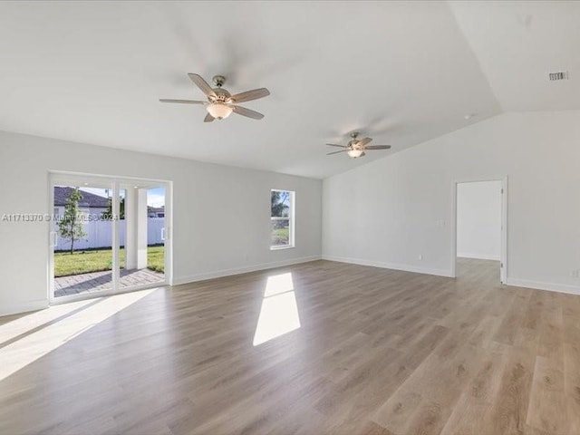 empty room with light hardwood / wood-style floors, ceiling fan, lofted ceiling, and plenty of natural light