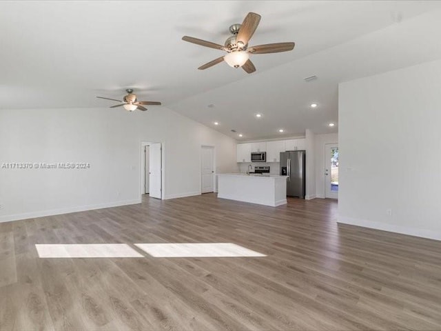 unfurnished living room featuring ceiling fan, vaulted ceiling, and light hardwood / wood-style flooring