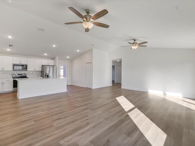 unfurnished living room featuring lofted ceiling, light wood-type flooring, and ceiling fan