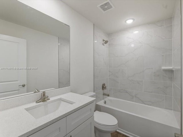 full bathroom with toilet, tiled shower / bath, and vanity