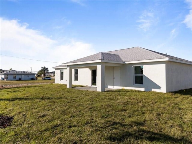 rear view of house featuring a yard