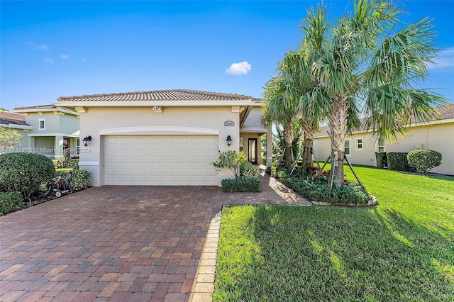 mediterranean / spanish-style house with a garage and a front lawn