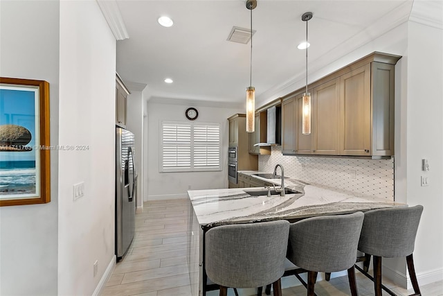 kitchen featuring sink, stainless steel refrigerator with ice dispenser, decorative backsplash, decorative light fixtures, and kitchen peninsula