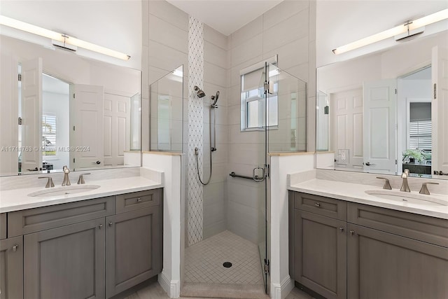 bathroom with vanity, a shower with shower door, and a wealth of natural light