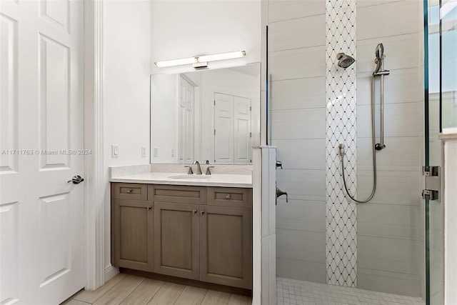 bathroom featuring a tile shower and vanity