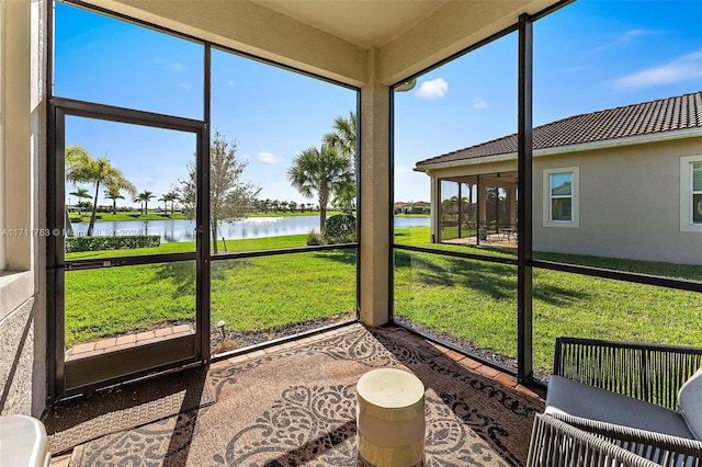 sunroom featuring a water view