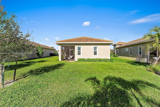 back of house with a yard and a sunroom