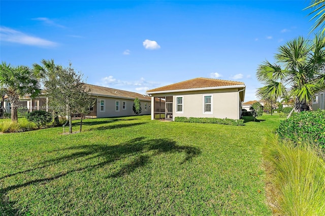 back of property featuring a sunroom and a yard